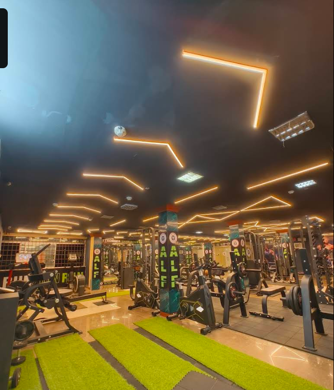 Trainer guiding a client at Alpha Fitness